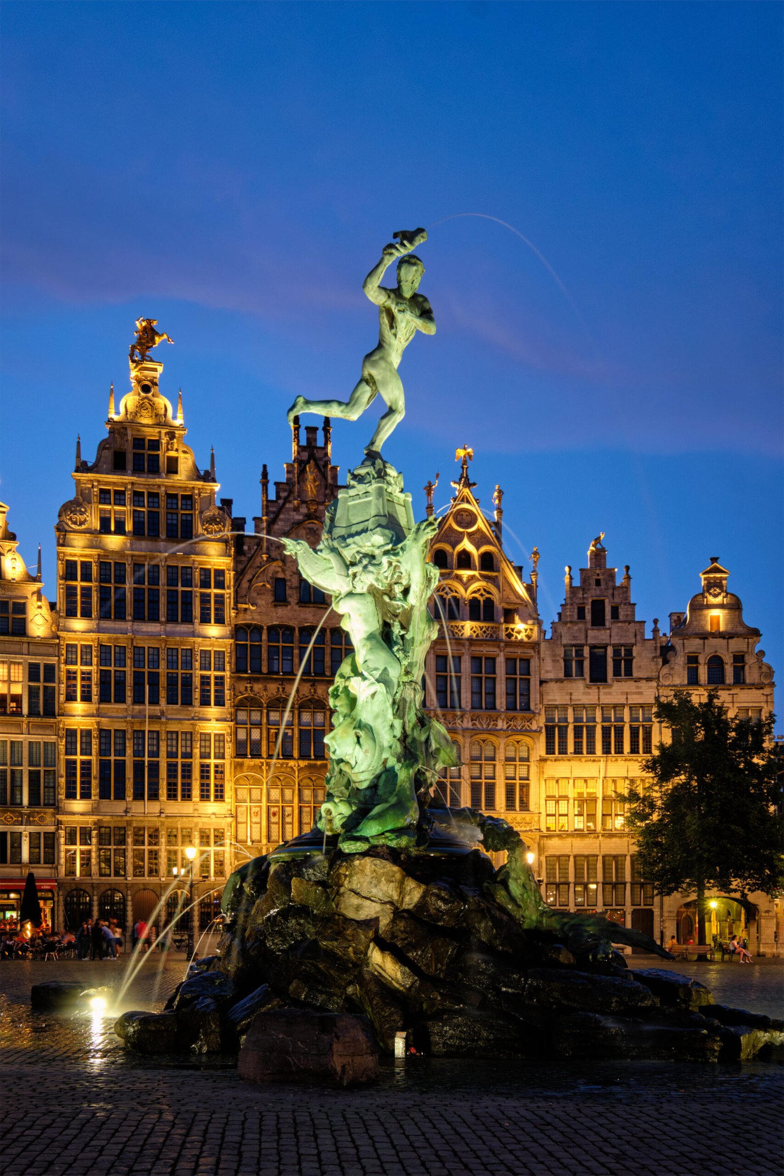 Antwerp famous Brabo statue and fountain on Grote Markt square illuminated at night and old houses. Antwerp, Belgium